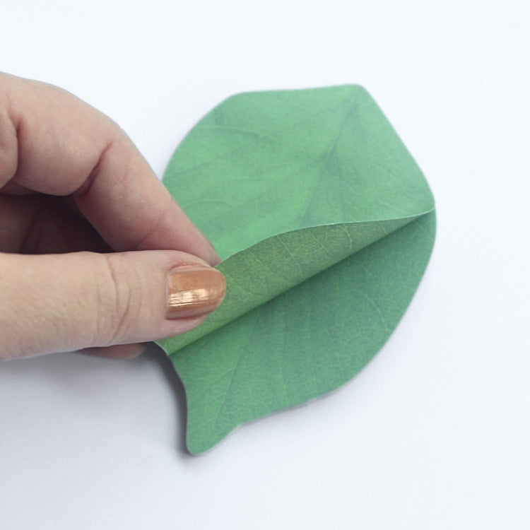 leaf shaped sticky notes being peeled off pad