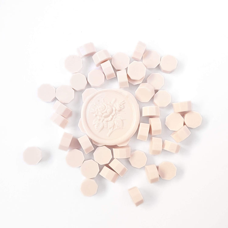 group of pastel pink sealing wax beads with pink wax seal on top