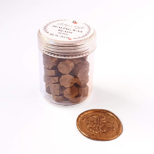Antique Gold sealing wax beads in jar with gols wax seal next to it