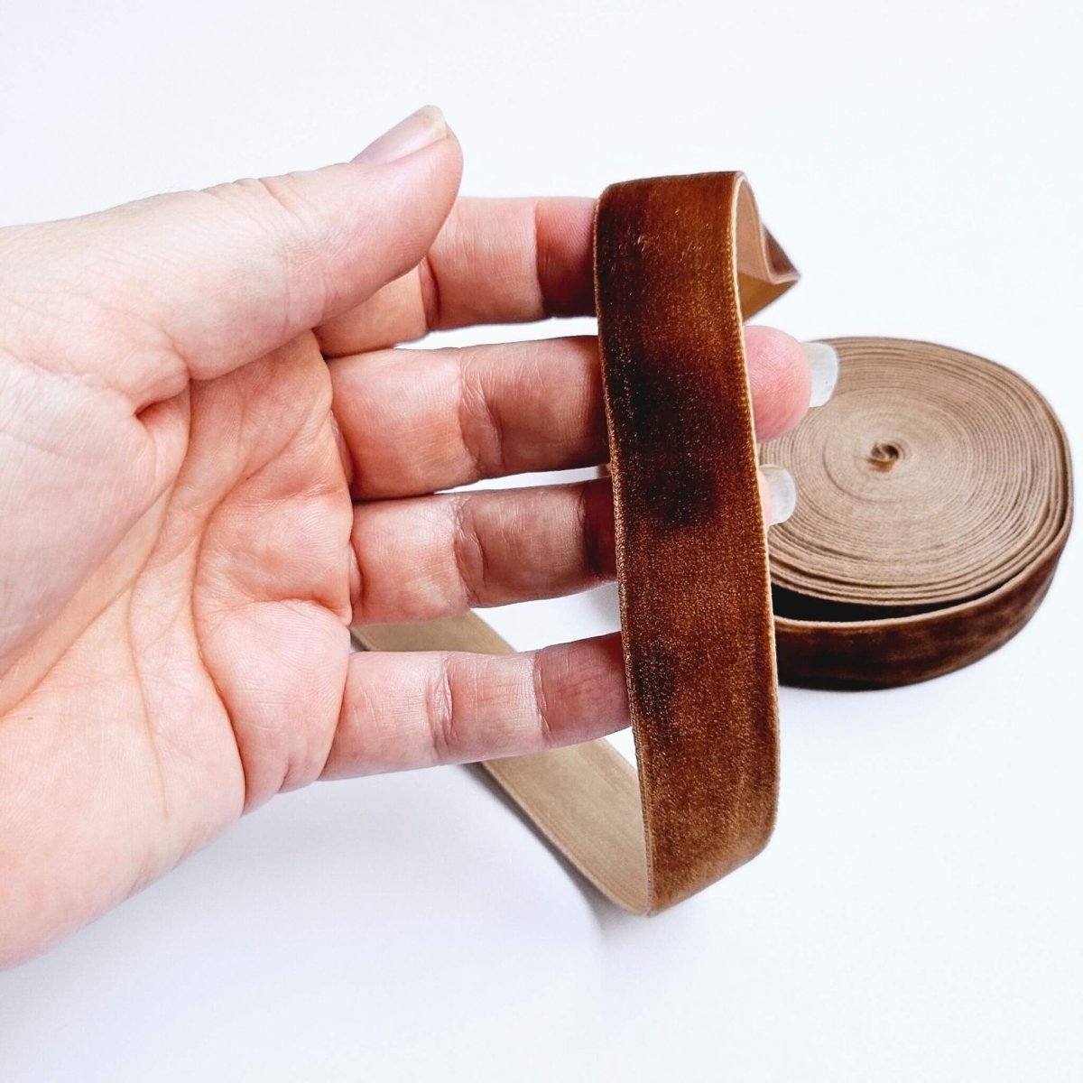 hand holding brown velvet ribbon
