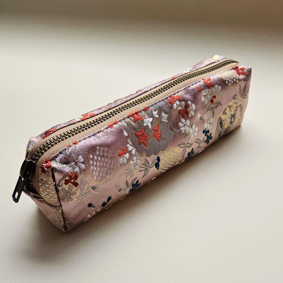 Floral embroidered pencil case pouch on a beige background