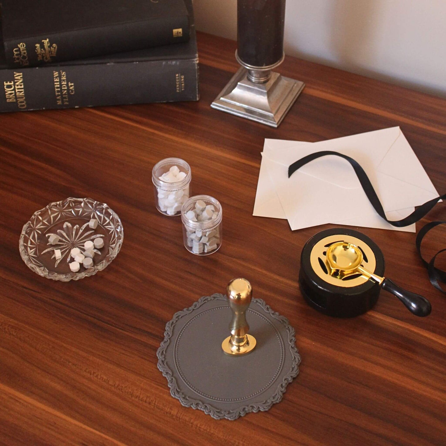 Wax seal kit with goddess design laid out on desk with wax sealing mat, sealing wax beads and black wax melting stove and spoon set