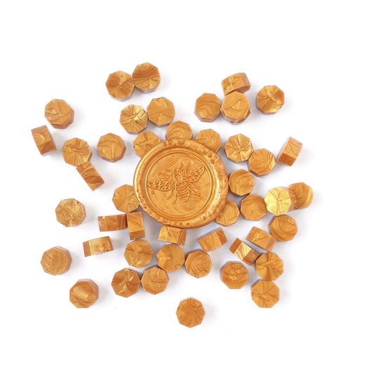 Gold sealing wax beads with a gold bee wax seal