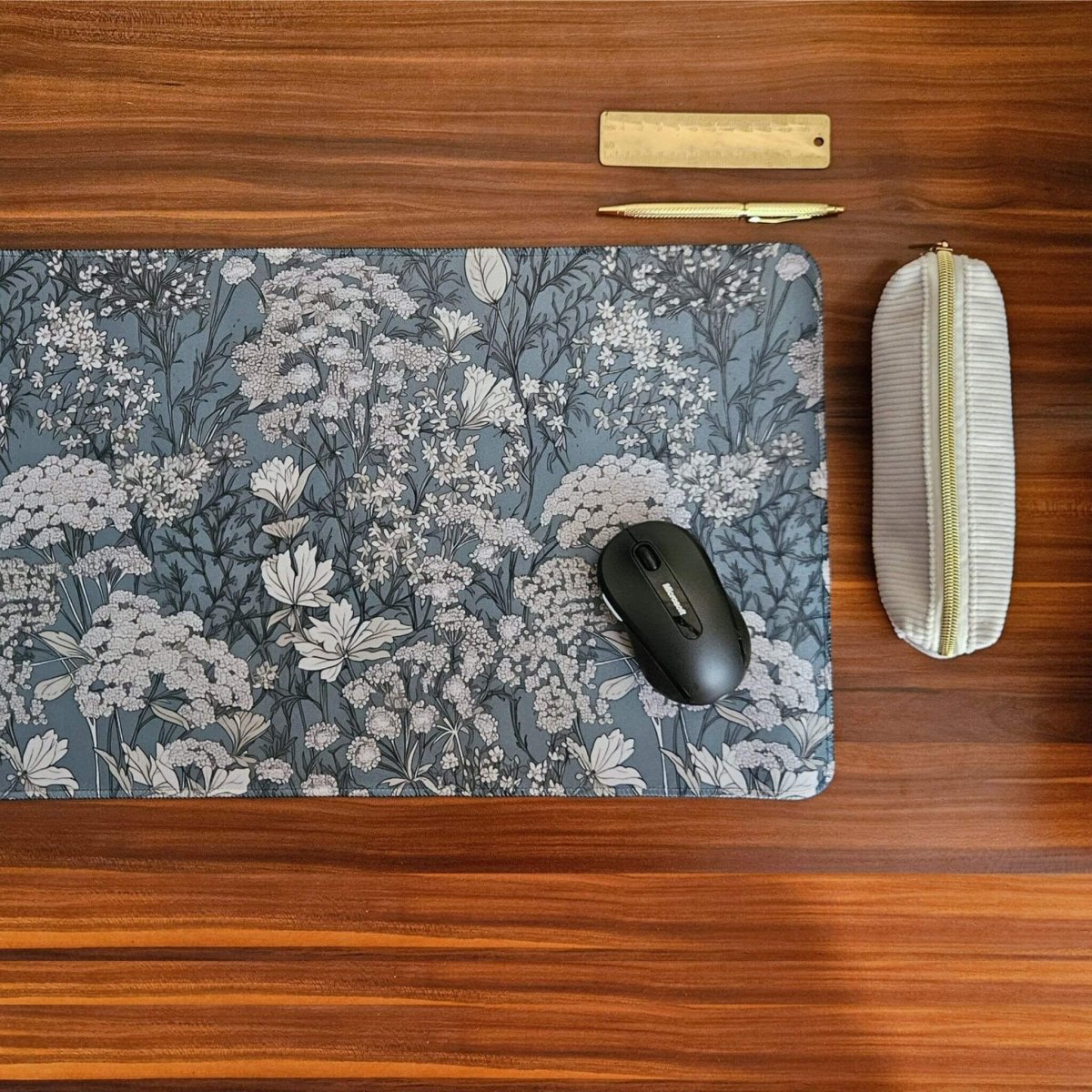Sage green floral desk mat with white pencil case and gold ruler and pen