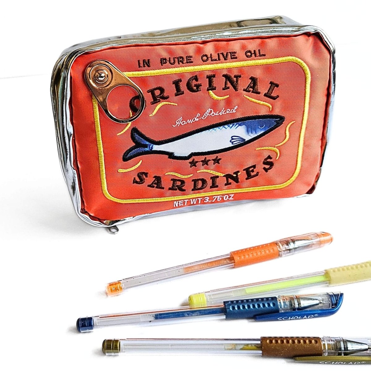 Pencil case designed like a vintage sardine can with pens on a white background