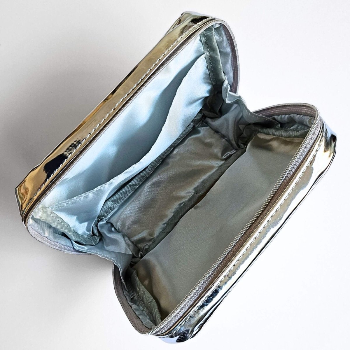 Metallic pencil case with a zipper and pocket on a light gray background