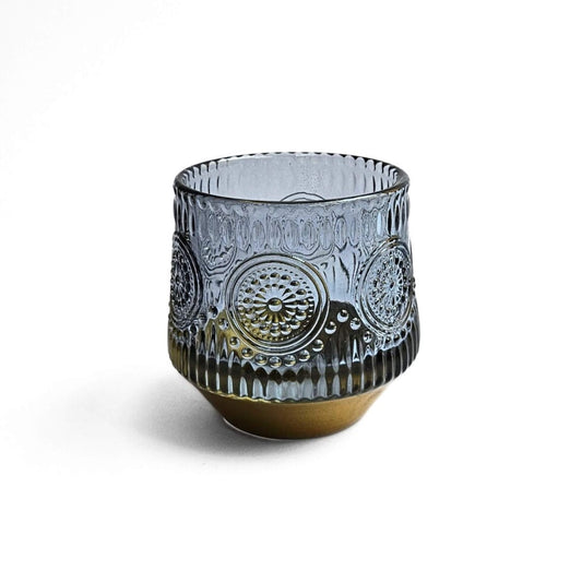 Decorative blue glass pen holder with intricate patterns on a white background