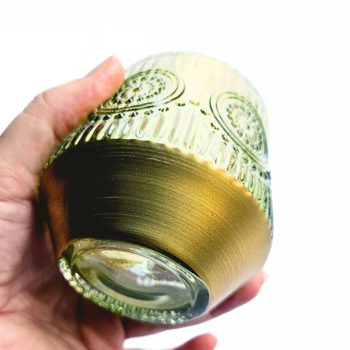 close up of gold hand painted base of green glass pen holder