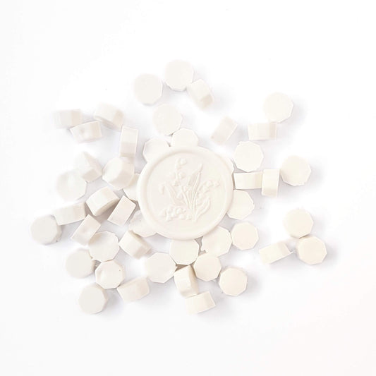 White sealing wax beads and a white wax seal with flower design