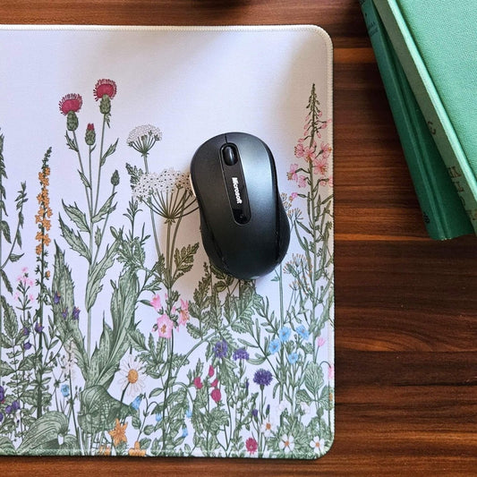 Mouse on a floral mouse pad on a wooden surface