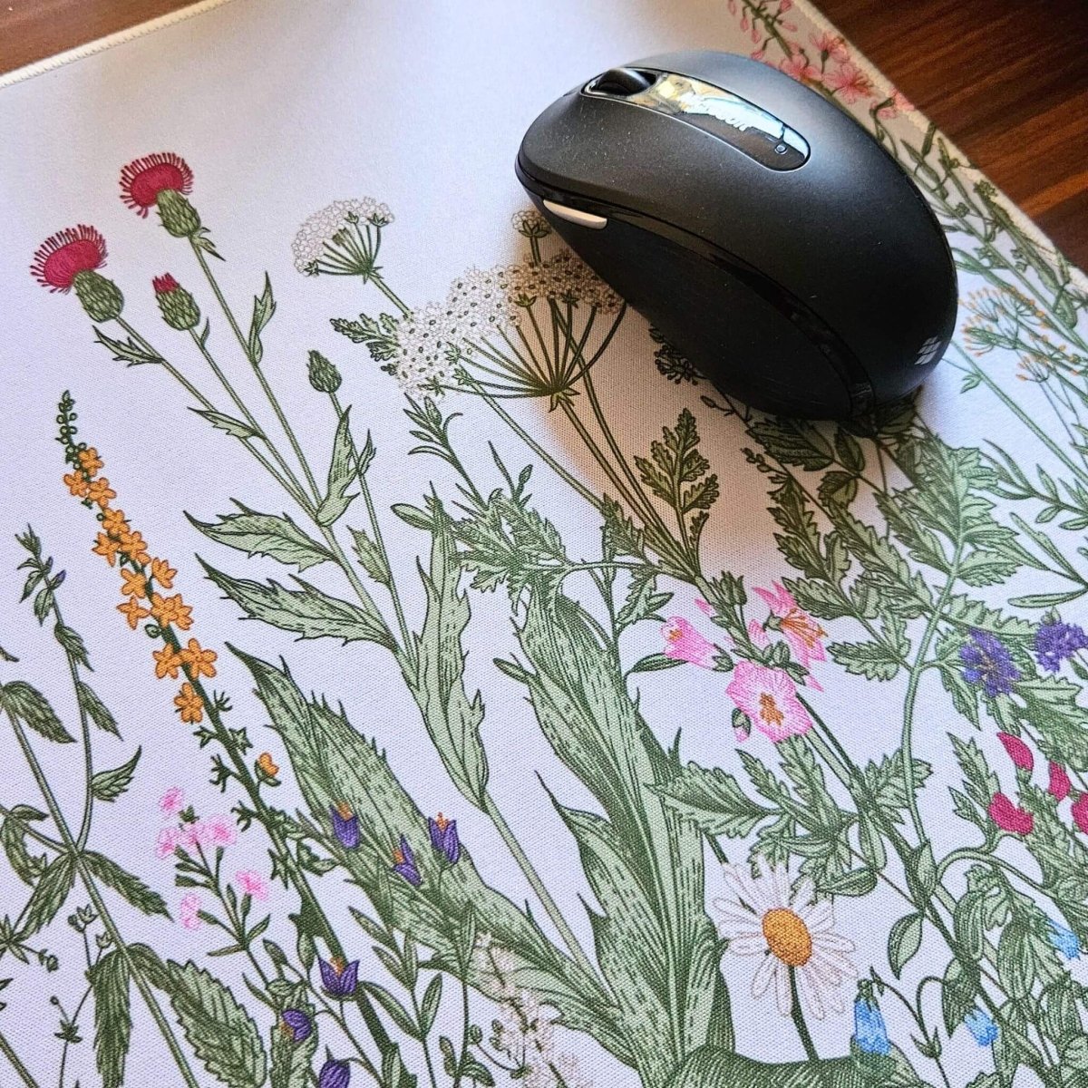 Black computer mouse on a floral-patterned mouse pad