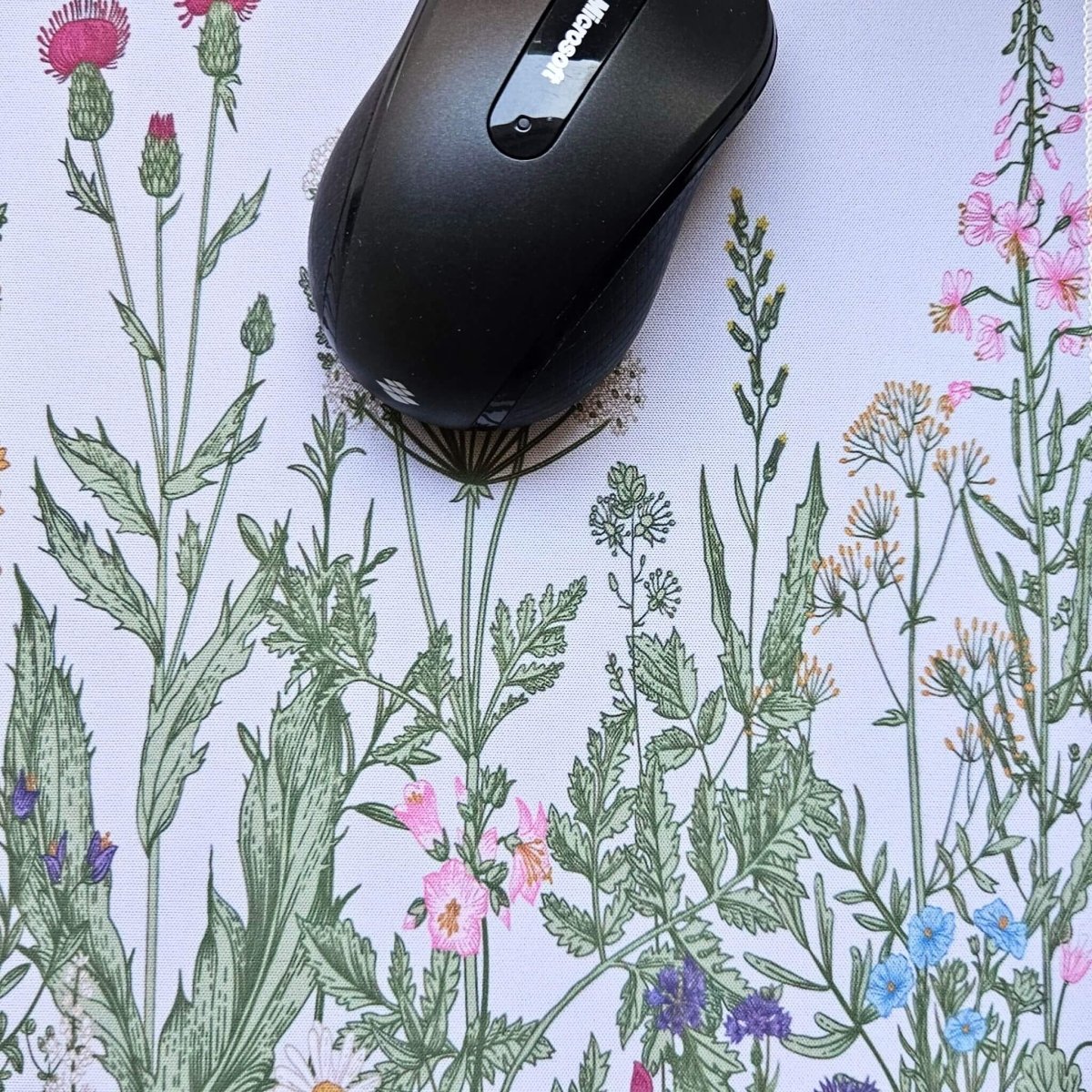 Black computer mouse on a floral-patterned surface