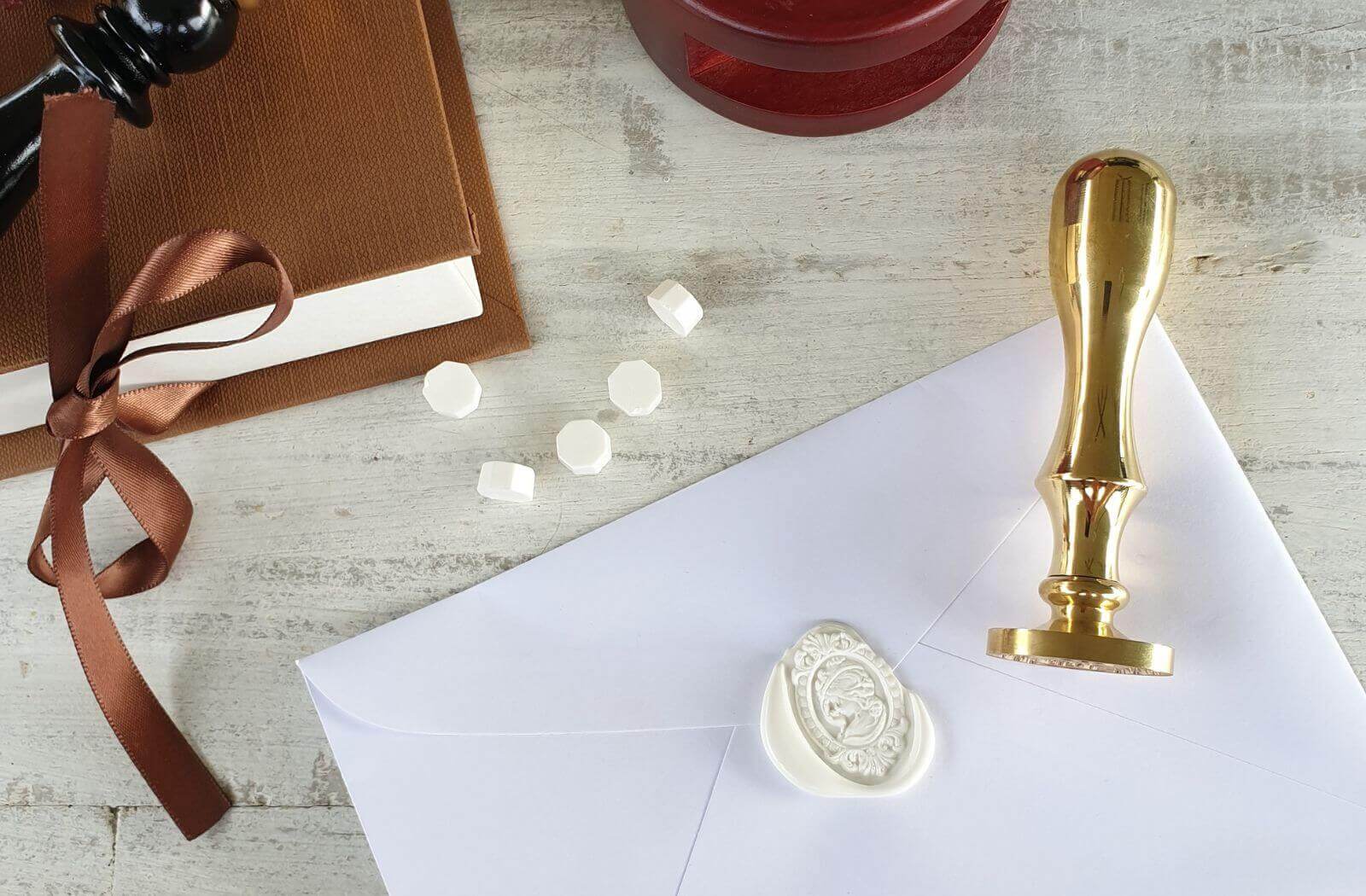 solid brass gold wax seal stamp on envelope with white wedding wax seal and wax sealing beads
