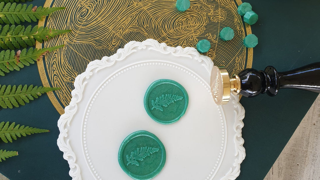 green wax seals with fern leaf design on wax sealing mat