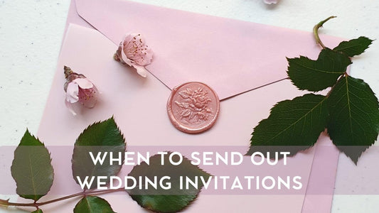 pink wedding invitation envelope with pink rose wax seal and flowers and leaves surrounding