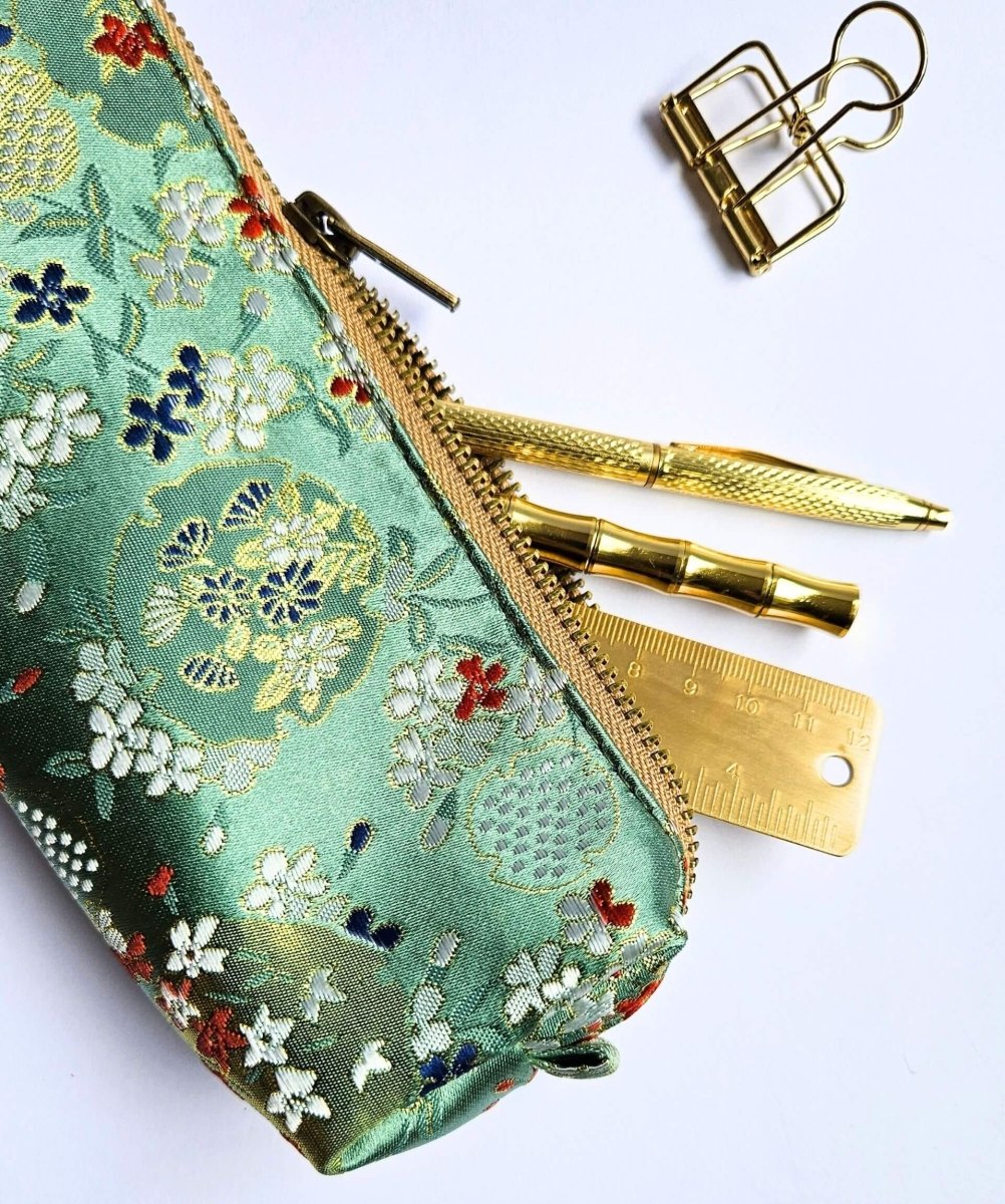 green floral pencil case with gold pens, ruler and clip