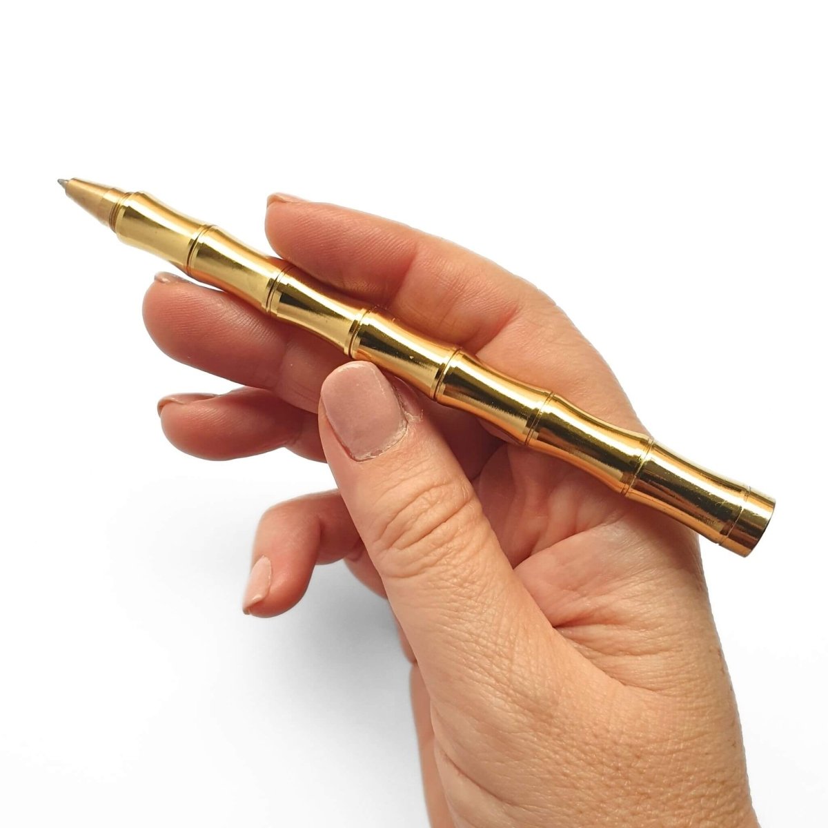 hand holding gold brass pen