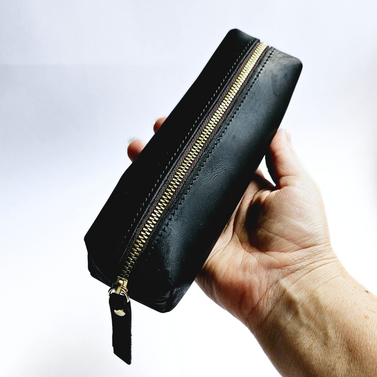 hand holding black leather men's pencil case