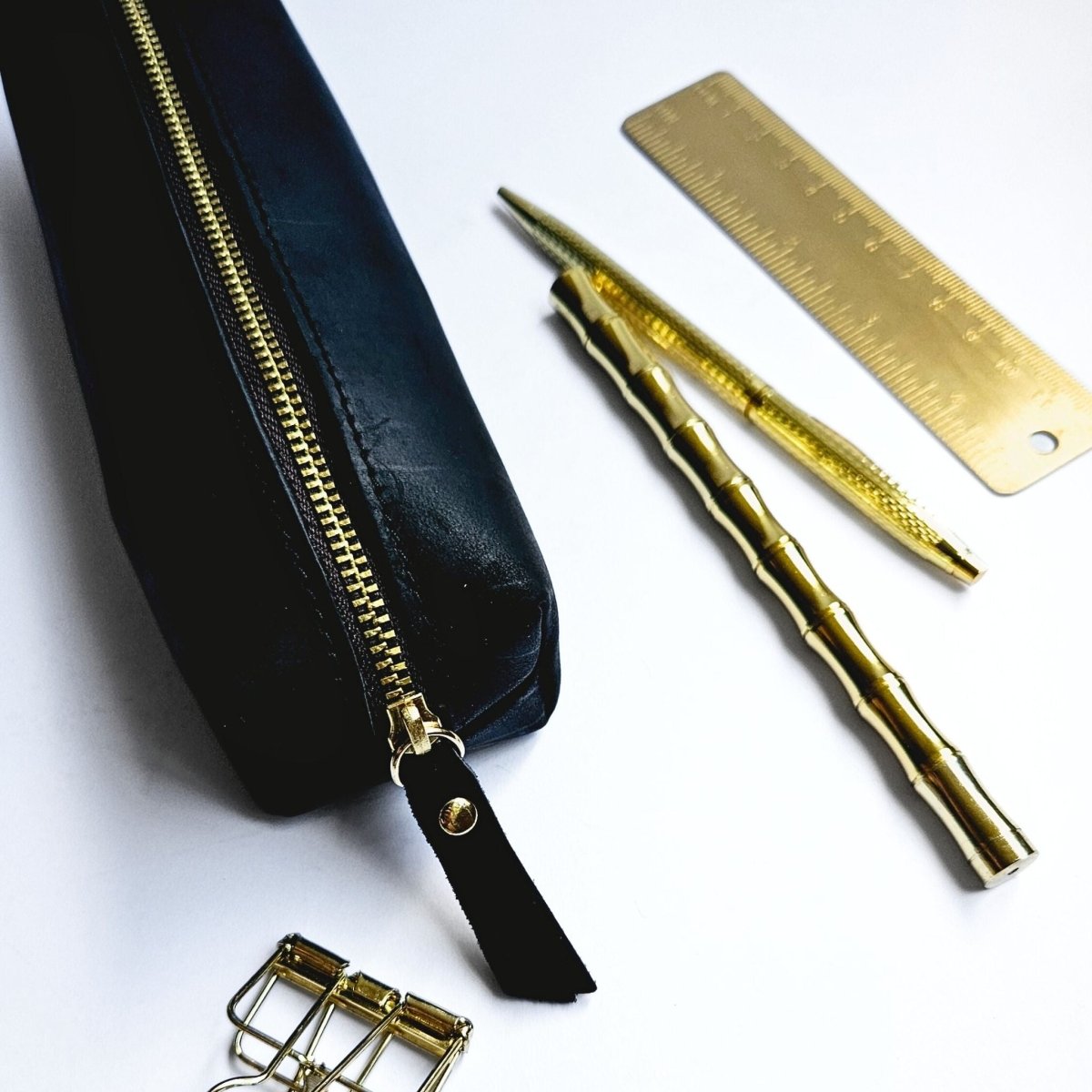 black leather pencil case with gold stationery