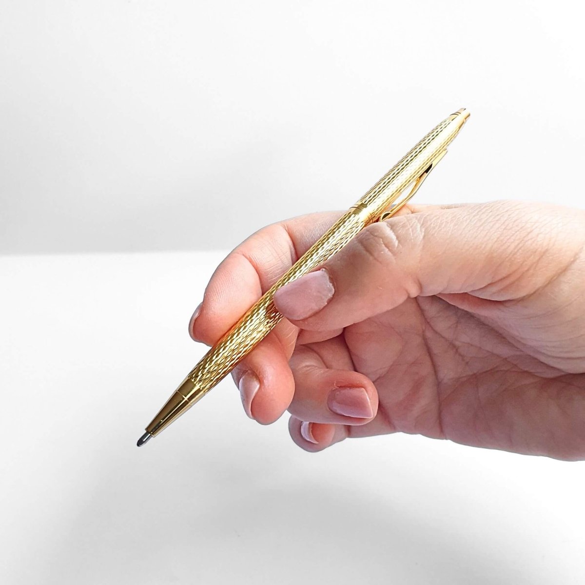 hand holding gold pen