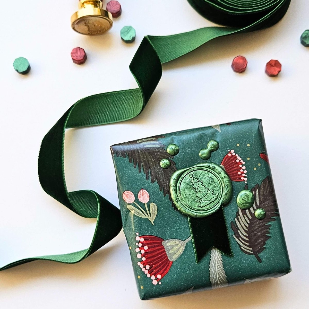 Christmas gift with green velvet ribbon and green wax seal with Christmas tree design