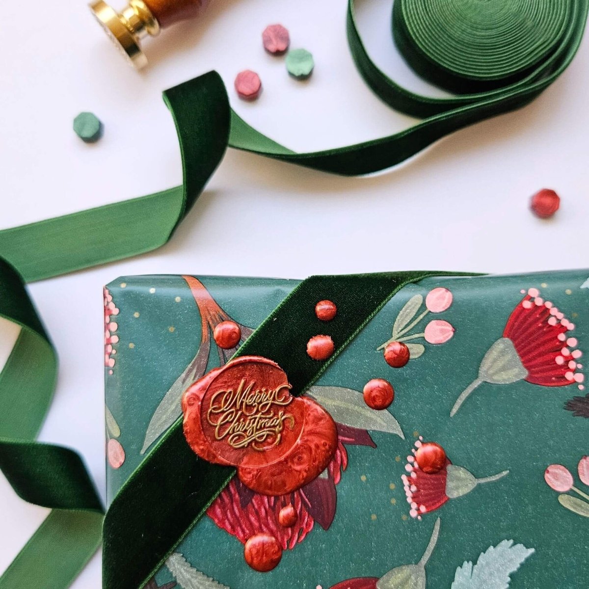 Red wax seal on Christmas present with "Merry Christmas" script design