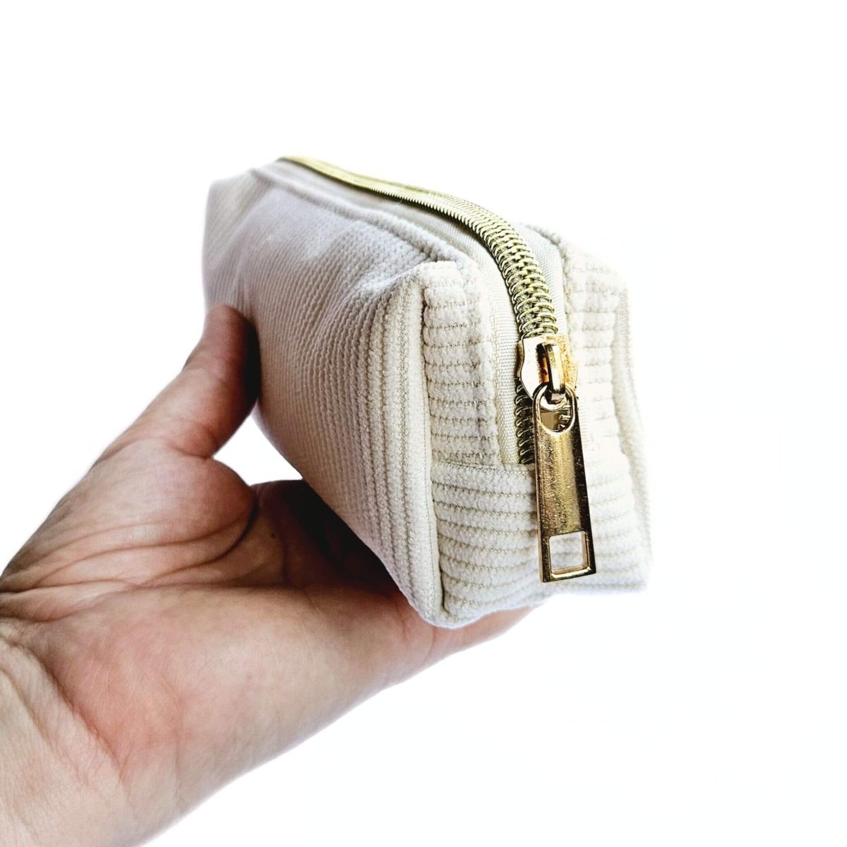 hand holding small white corduroy pwncil case