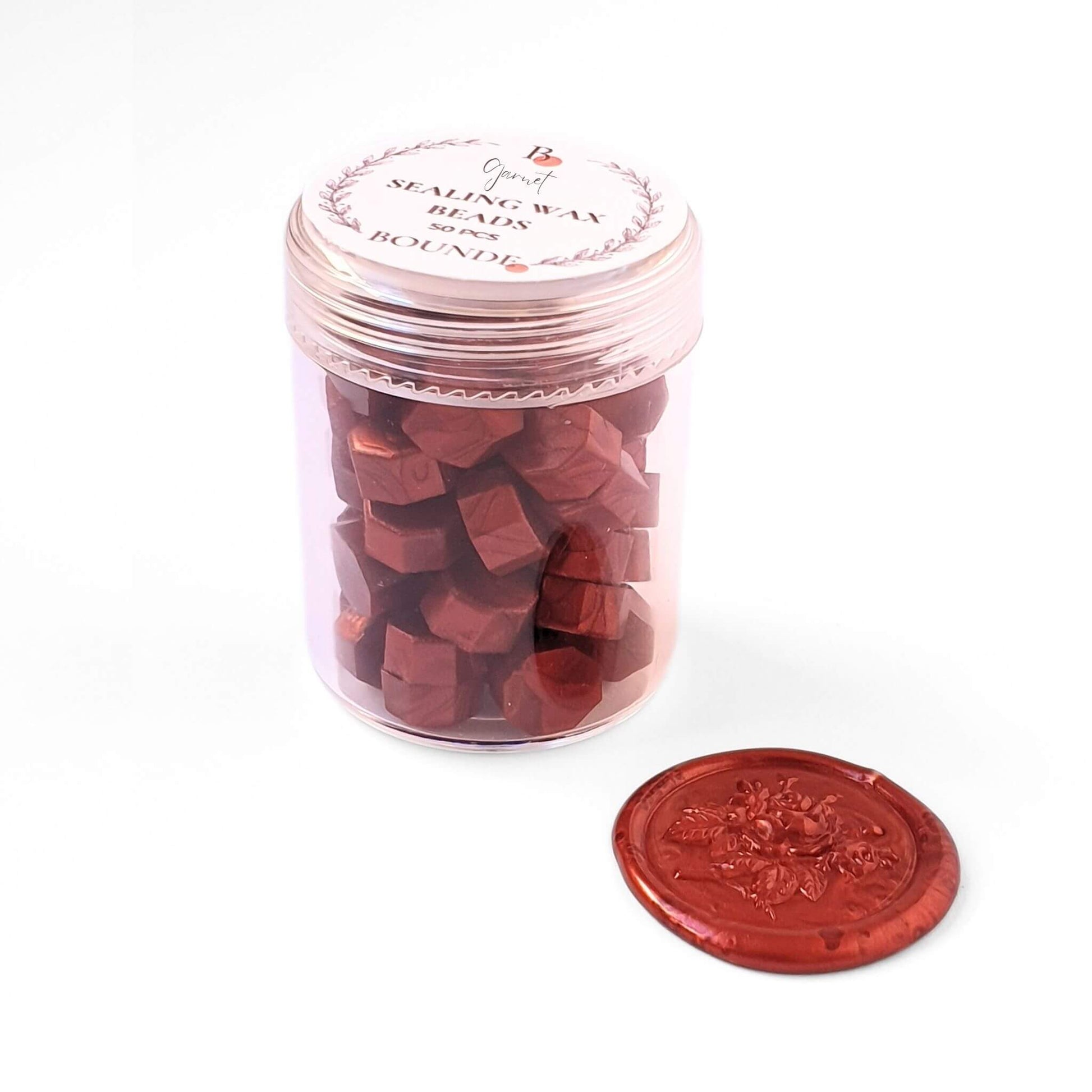 Garnet red sealing wax beads in jar with red wax seal next to it