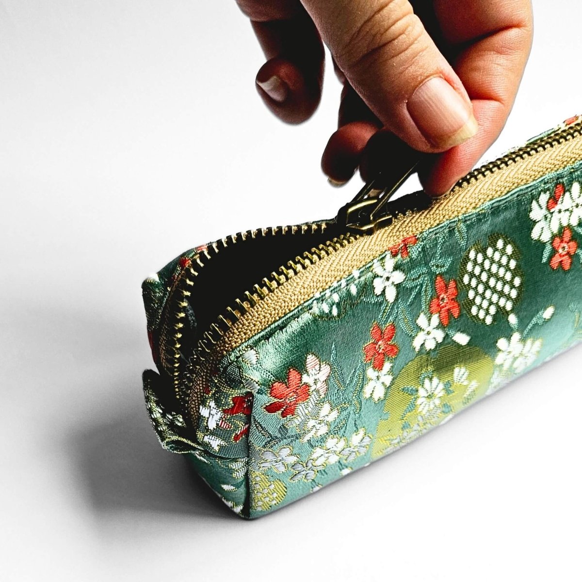 hand unzipping green pencil case