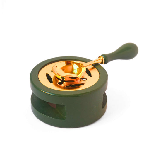 Green and gold wooden wax melting stove with matching spoon on top