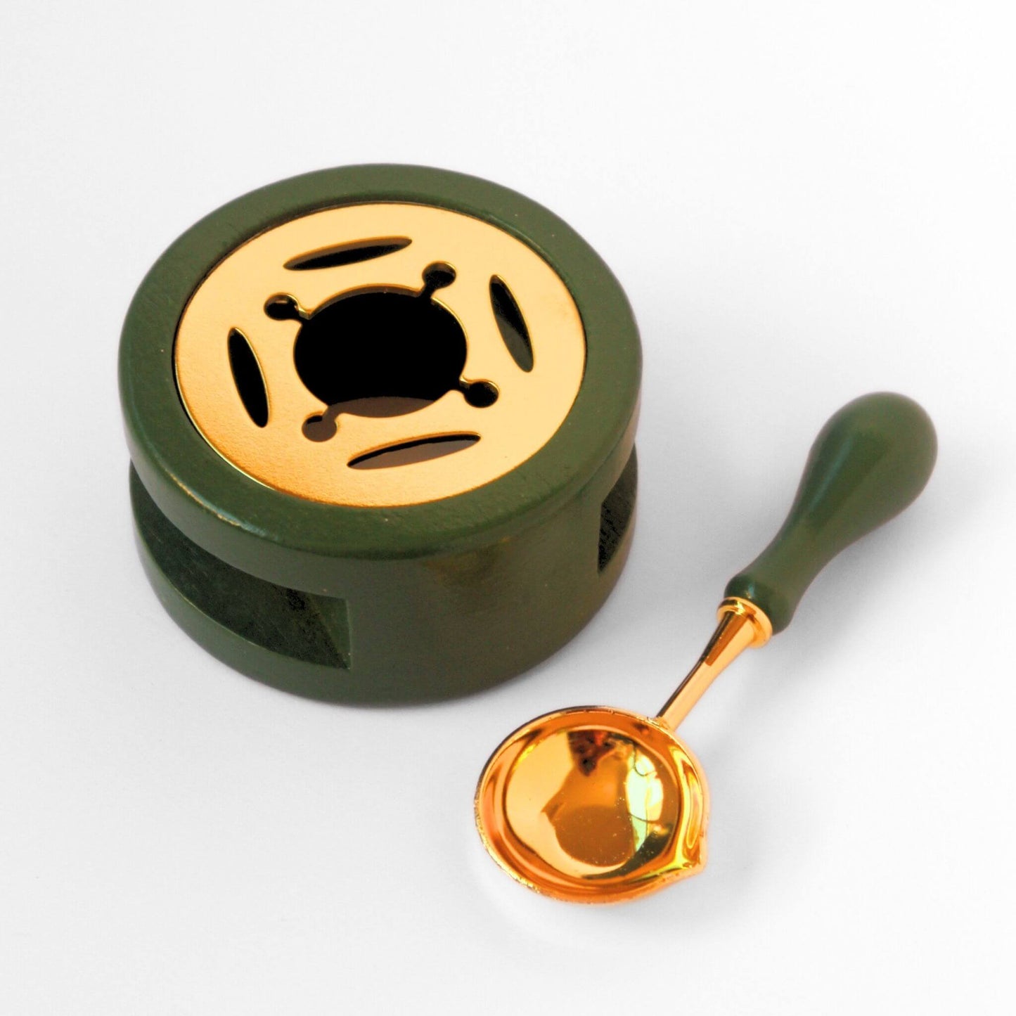 green and gold wax melting stove with matching spoon laid beside