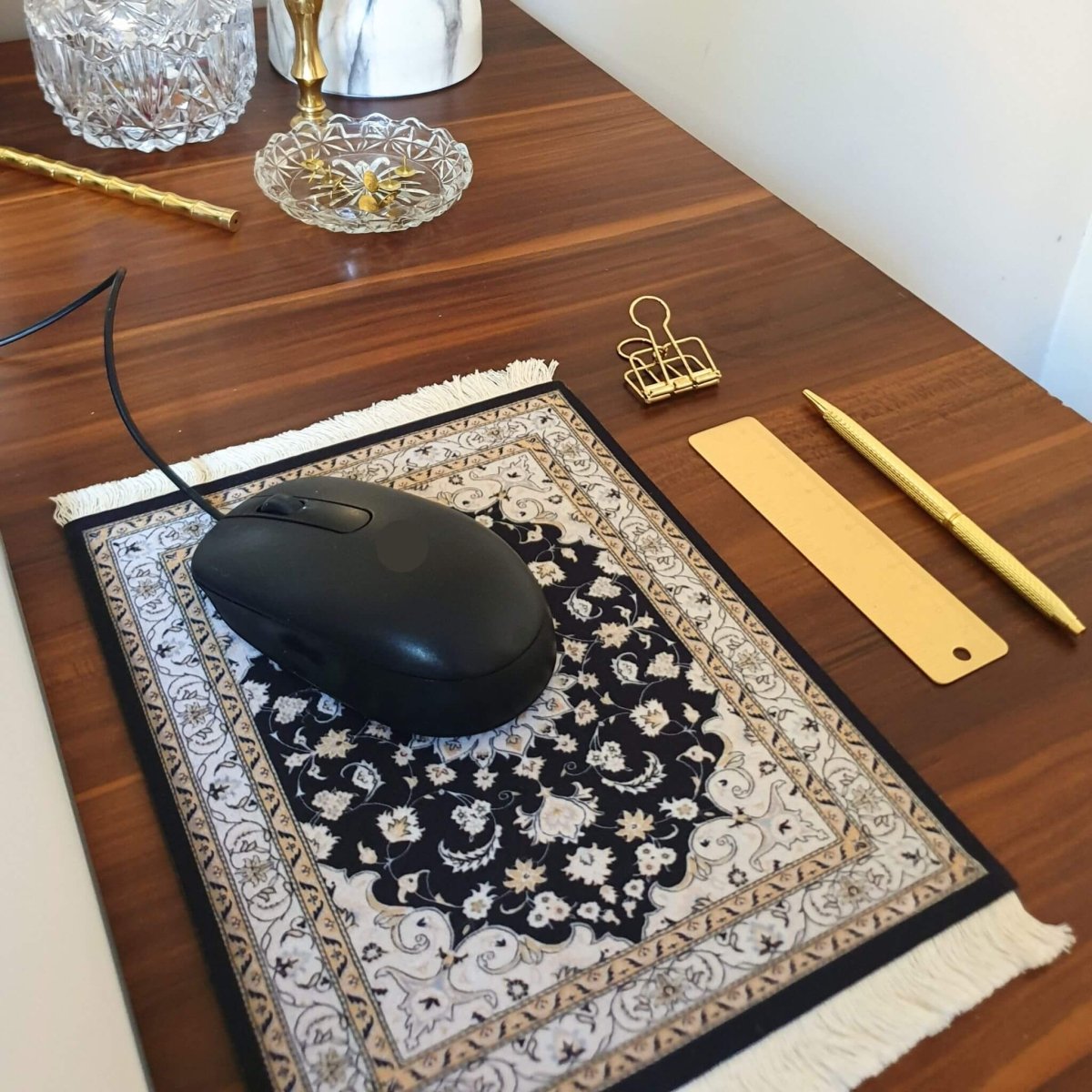 Office desk woth small rug mouse pad nest to laptop with computer mouse