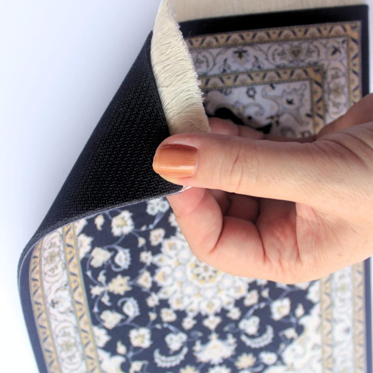 Hand showing underside of oriental carpet mouse pad
