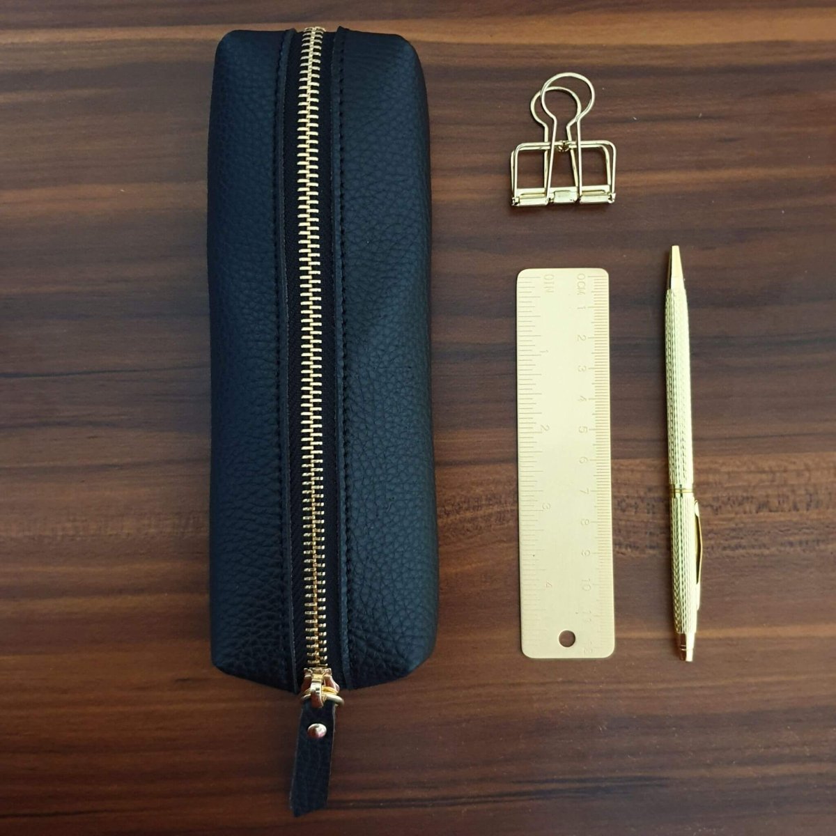 office desk with black pencil case and gold stationery