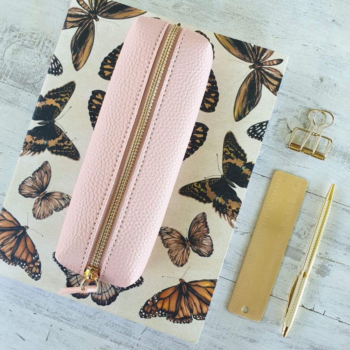 butterfly print notebook with pink pencil case on top