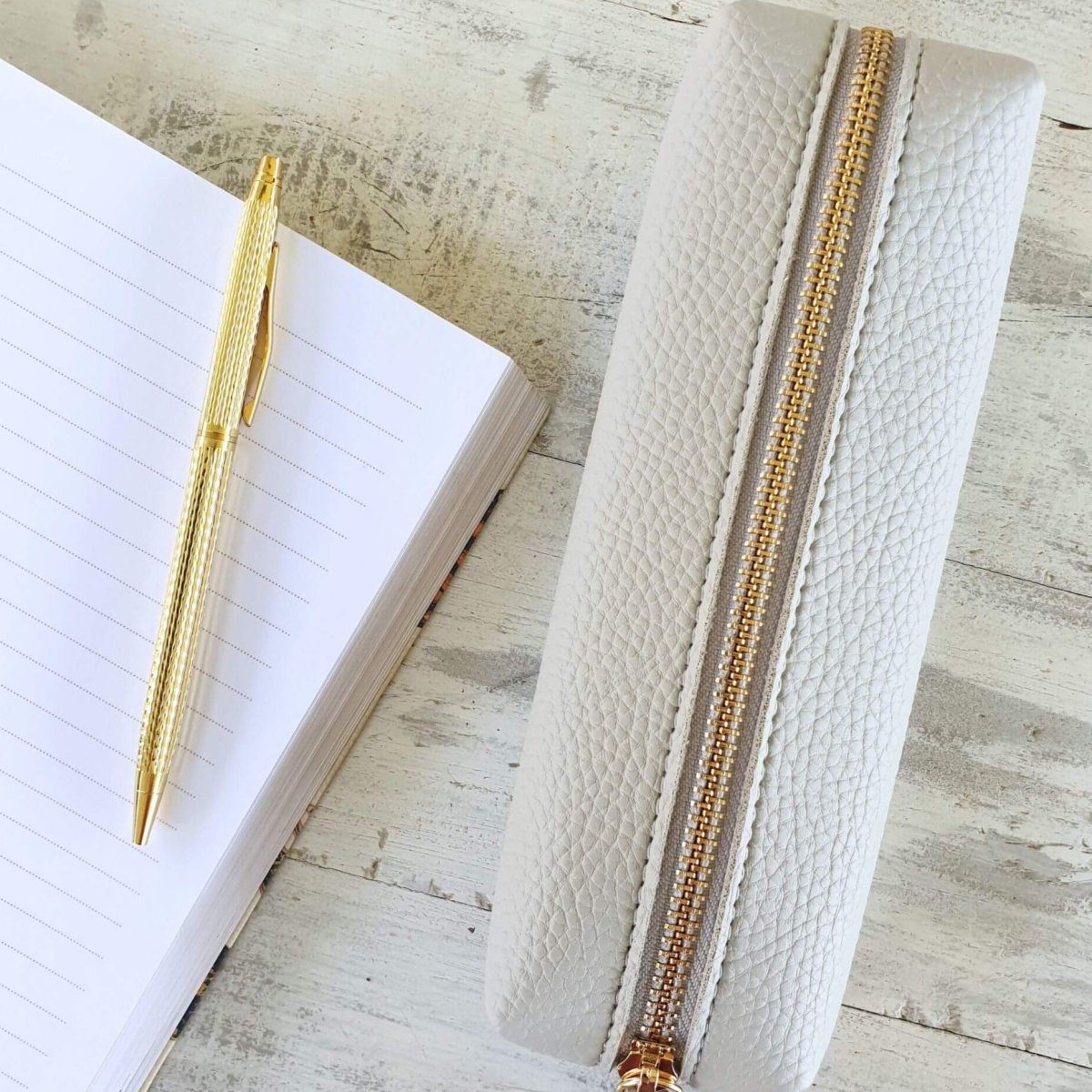 gold pen with pencil case on desk