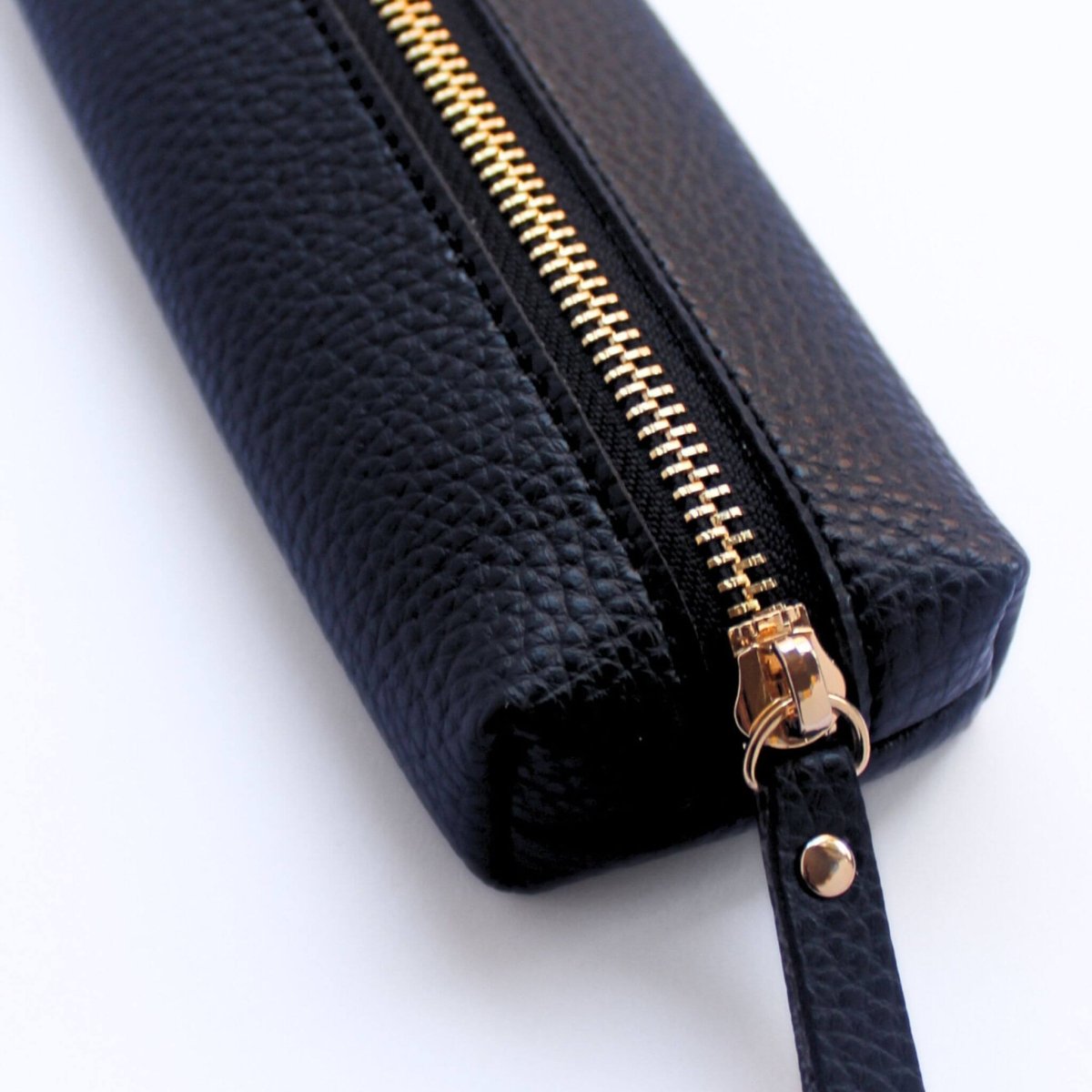 Close up of black vegan leather pencil case with gold zipper