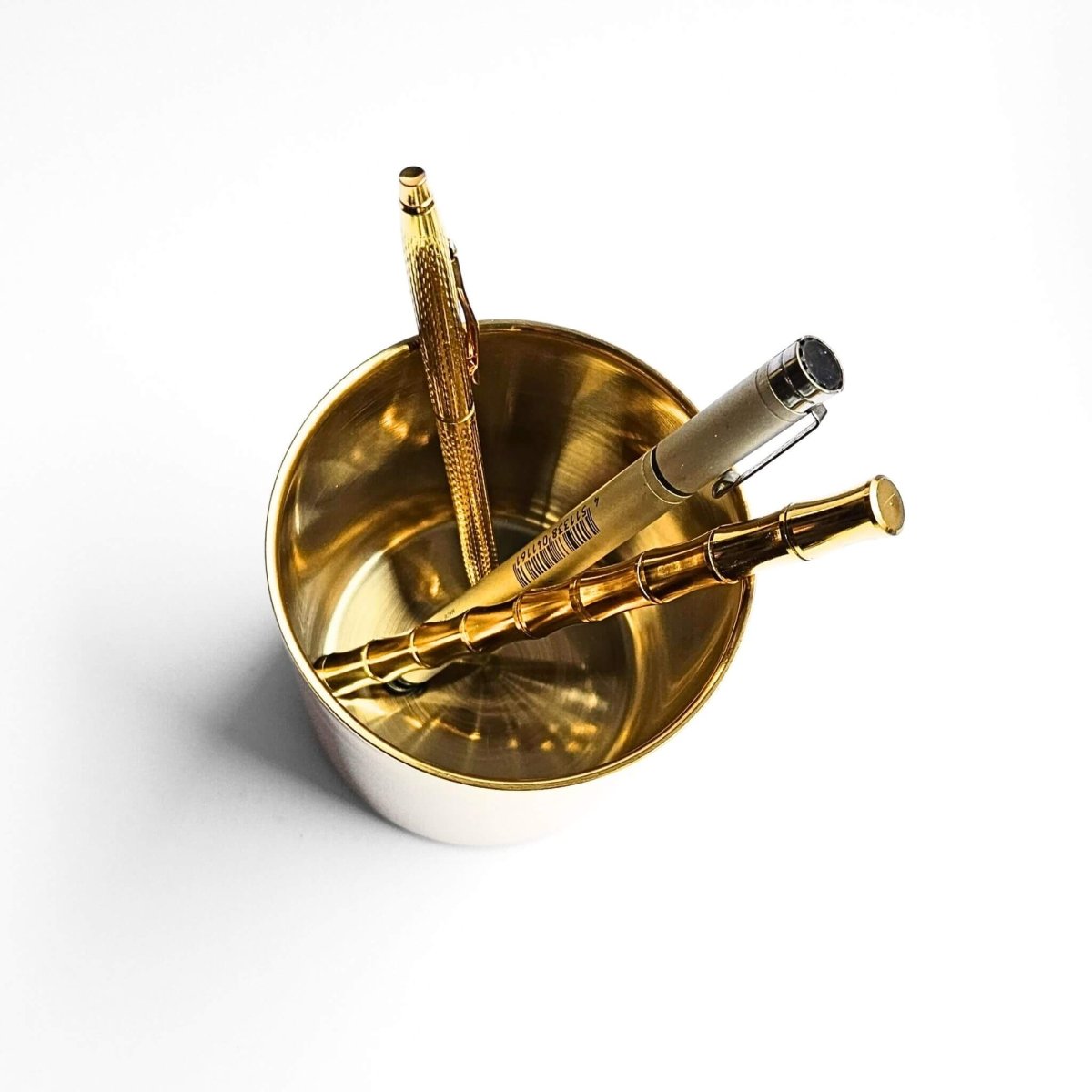 overhead view of gold metal pen cup