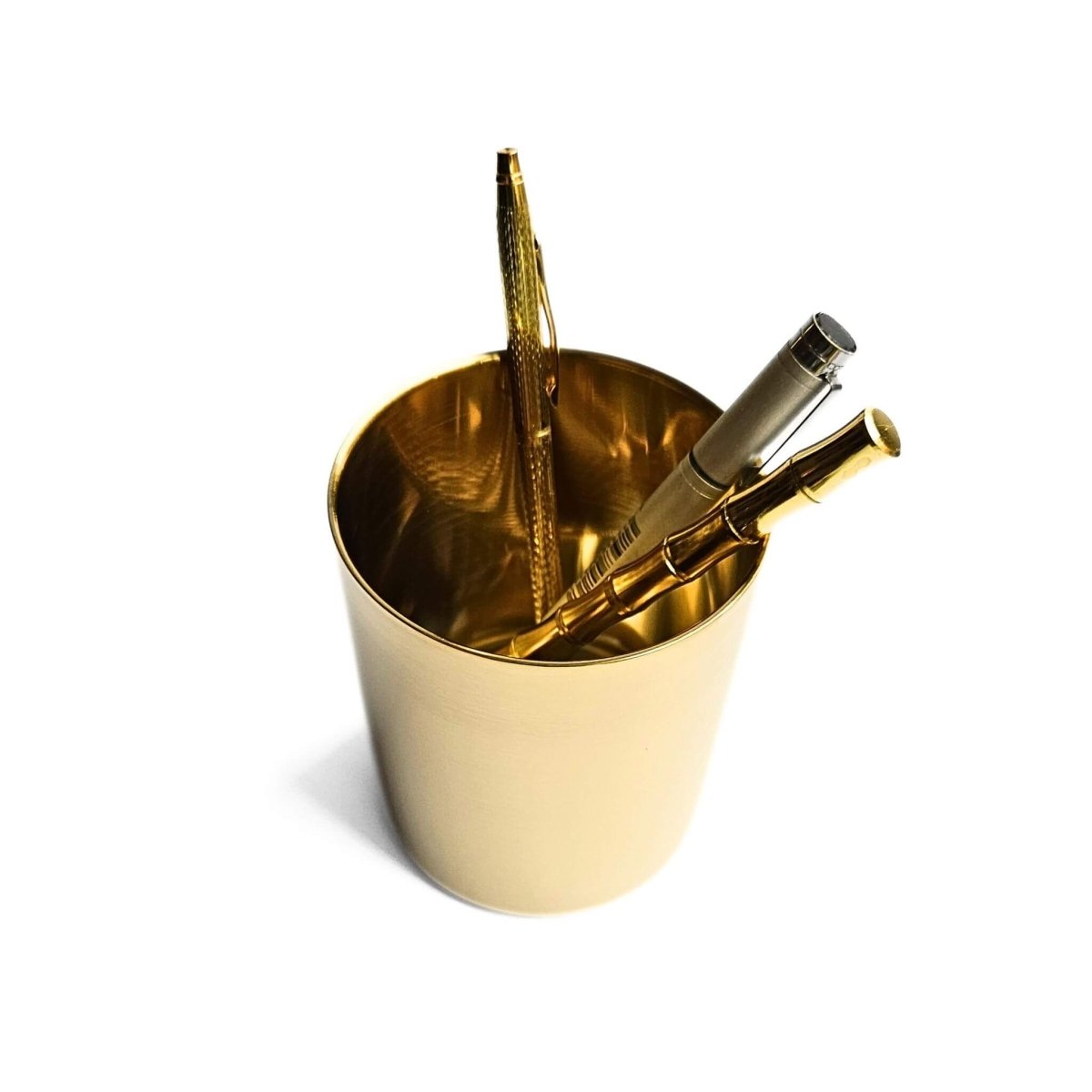 gold pen cup made from metal with pens inside