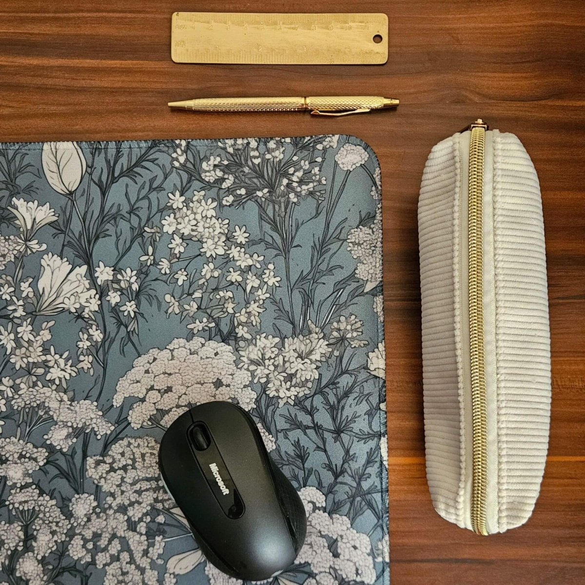 Sage green and white floral desk mat with computer mouse and cream pencil case