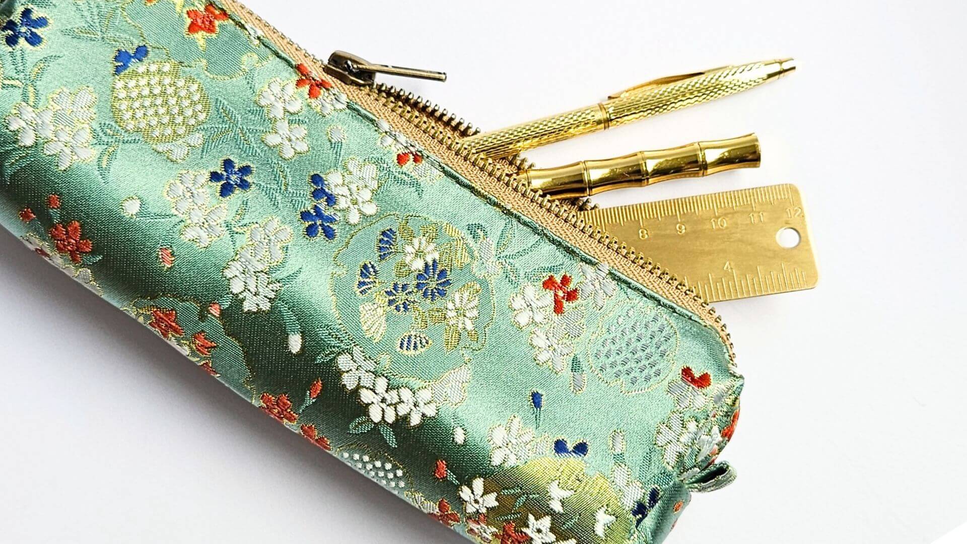 mint green floral embroidered pencil case with gold pens and ruler