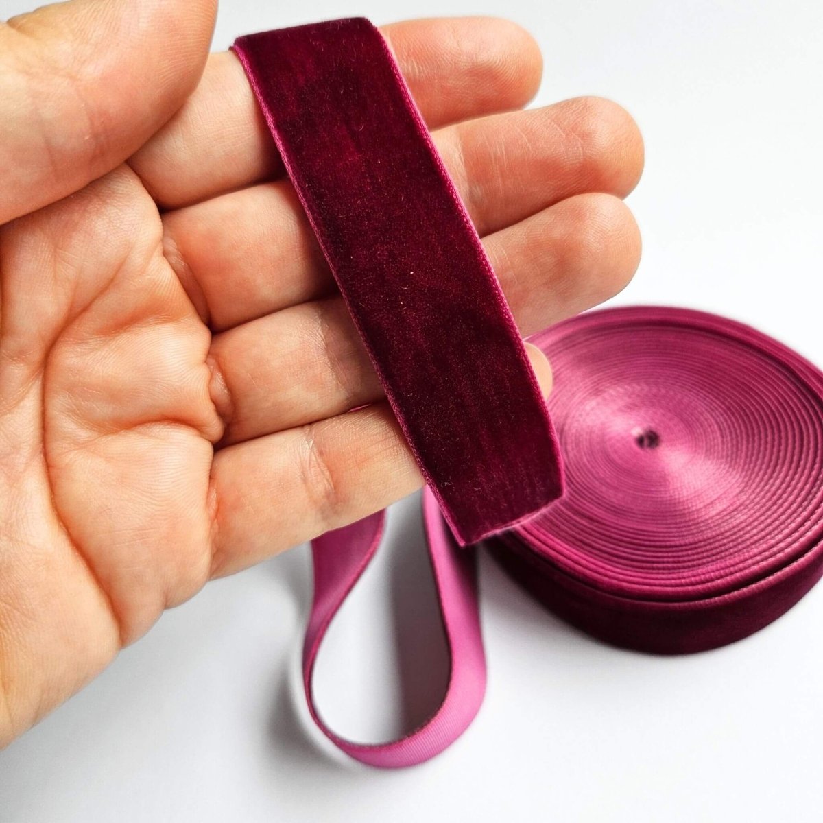 hand holding wine coloured velvet ribbon