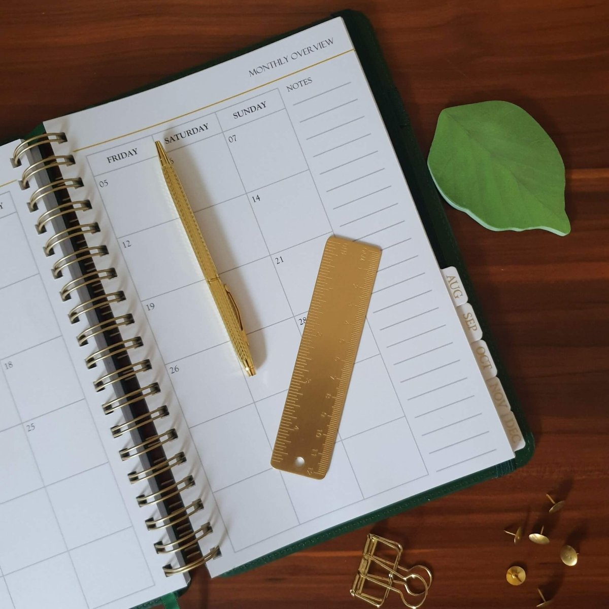 leaf sticky notes with planner, pen and ruler on desk