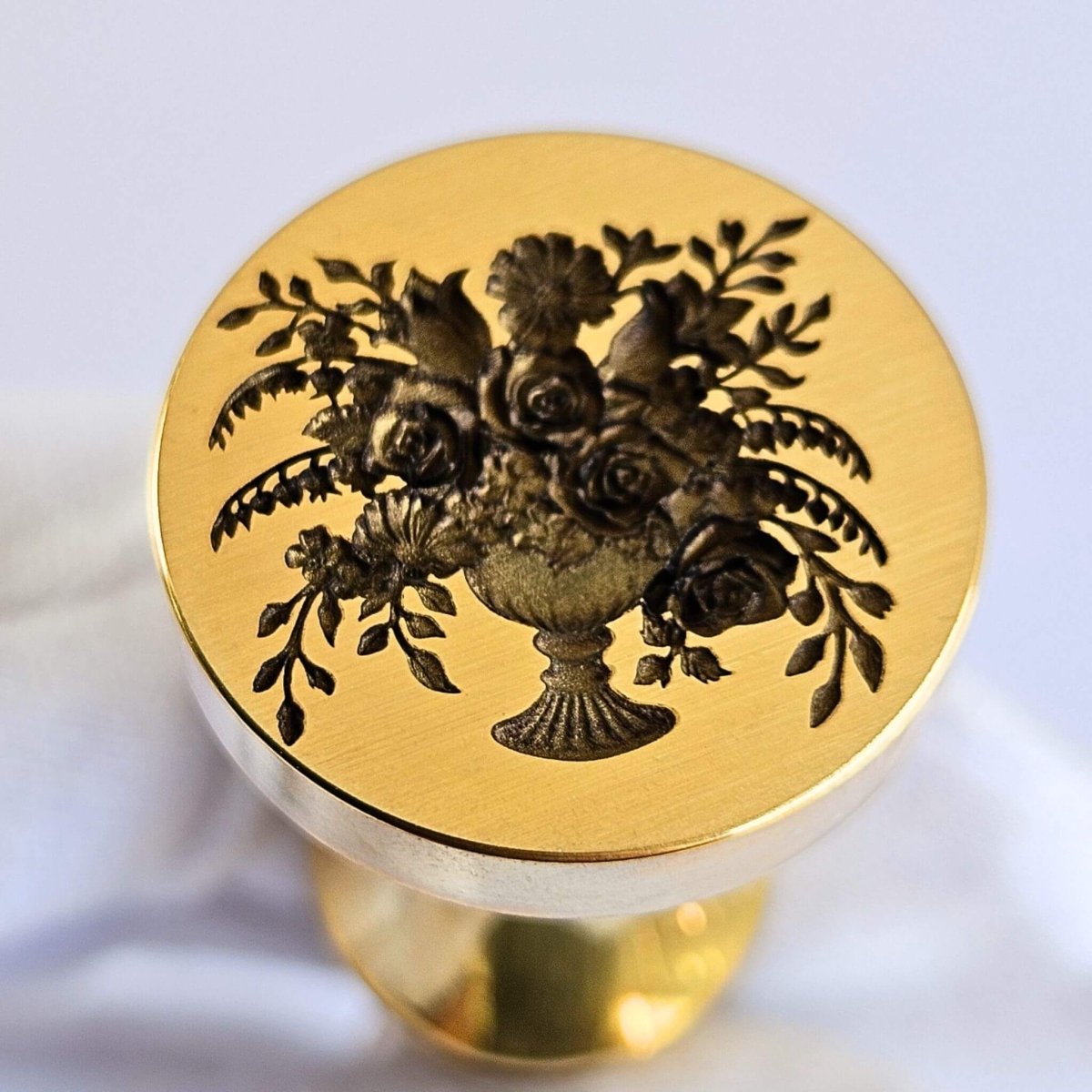 Brass Wax seal with floral vase design on a white background