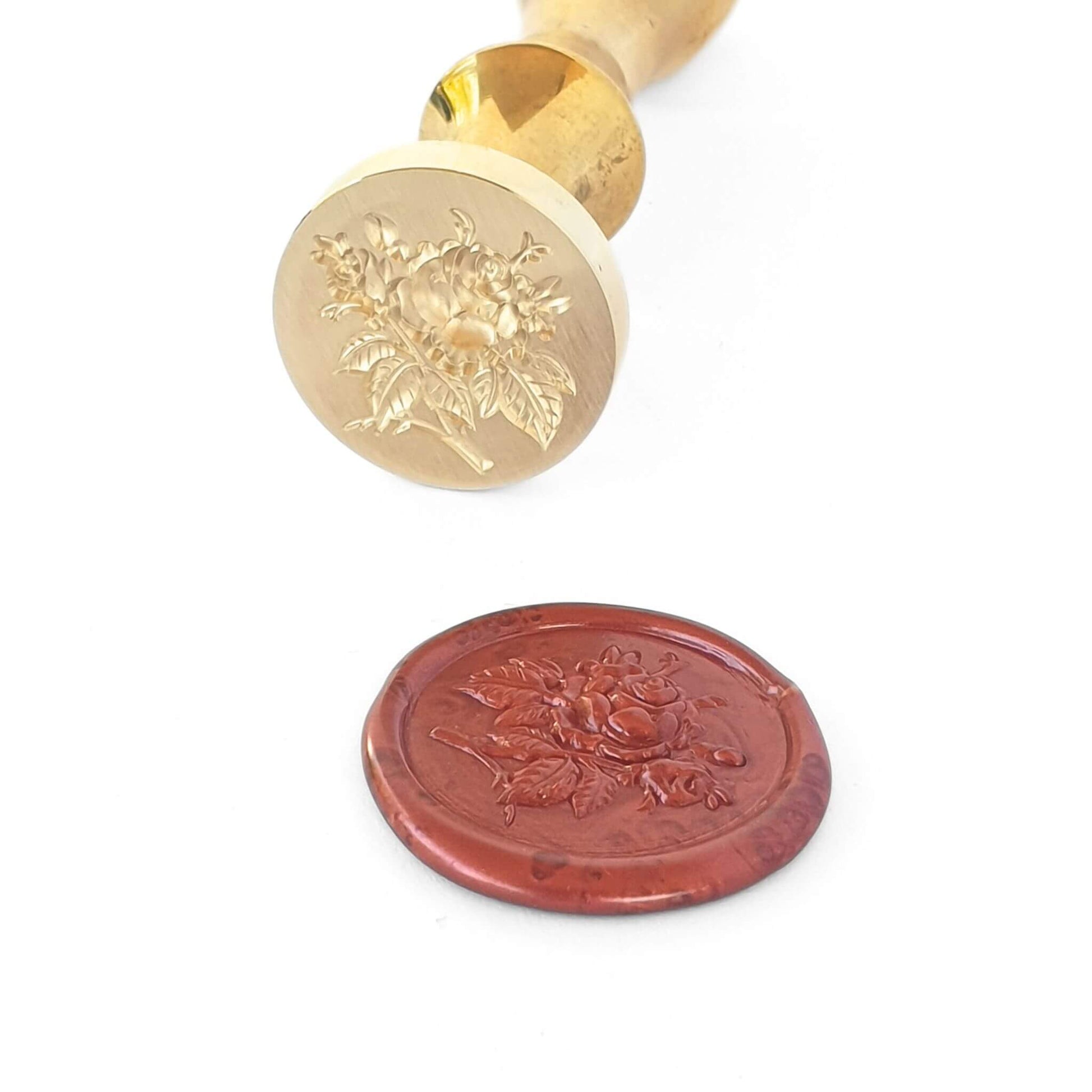 Rose wax seal made from solid brass with gold finish next to red rose wax seal