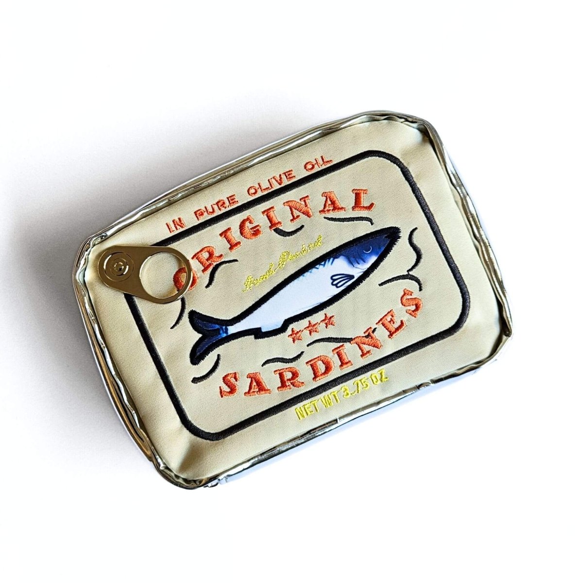Gold sardine can-shaped pencil case with orange text embroidery and fish illustration on a white background