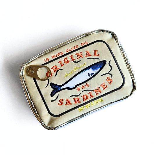 Gold sardine can-shaped pencil case with orange text embroidery and fish illustration on a white background