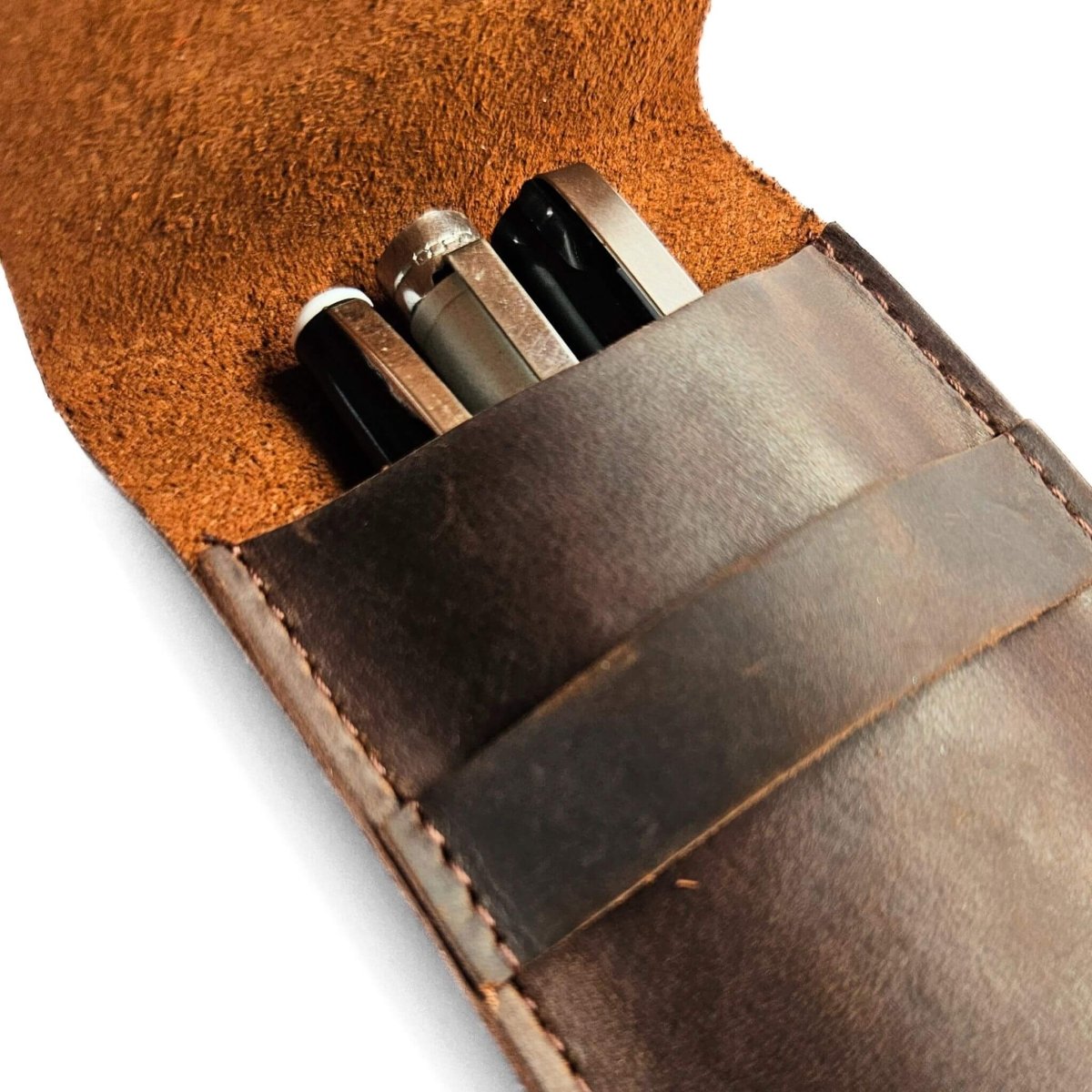 close up of leather pen pouch with three pens inside