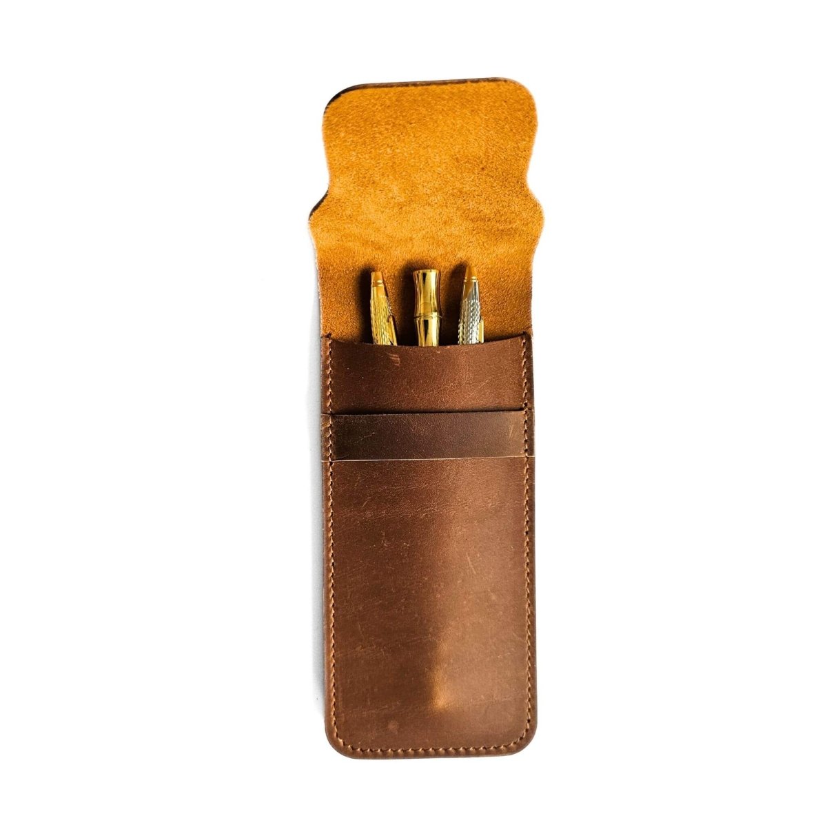 Brown leather pen case with gold pens on a white background