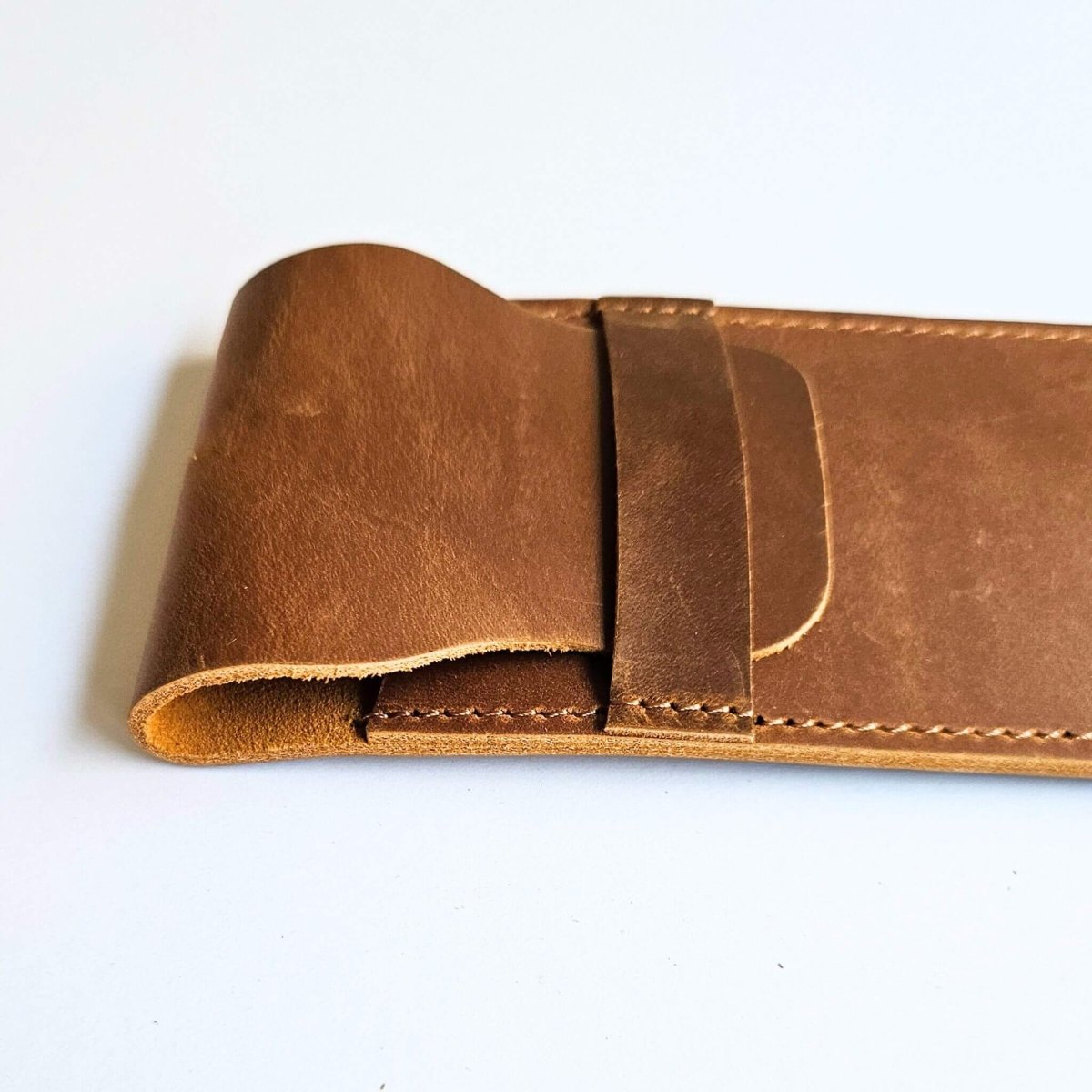 Close up og tan brown leather pen case on a white background